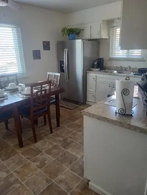 a kitchen with a table and a refrigerator at Franklin Apt in Fresno