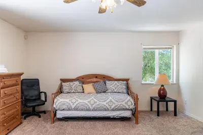 a bedroom with a bed and a chair and a window at Groveland 2BR Home - Mountain Retreat in Groveland