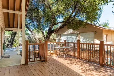 a wooden deck with a table and a tree at Groveland 2BR Home - Mountain Retreat in Groveland