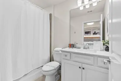 a white bathroom with a toilet and a sink at NEW 10BD At Windsor Cay Pool and Game Room