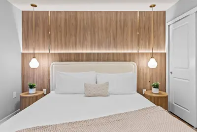 a bedroom with a large white bed with wooden walls at NEW 10BD At Windsor Cay Pool and Game Room
