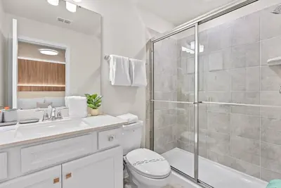 a bathroom with a shower and a toilet and a sink at NEW 10BD At Windsor Cay Pool and Game Room