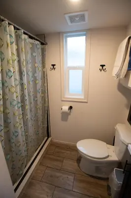a bathroom with a toilet and a shower curtain at Tiny Blue at Yosemite Gateway in Groveland