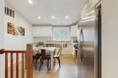 a kitchen with a table and a stainless steel refrigerator at Sierra Solace in South Lake Tahoe