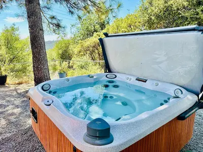 a jacuzzi tub sitting next to a tree at Fun for 2-Hot Tub-Dogs Ok-Near Bass Lake in Oakhurst