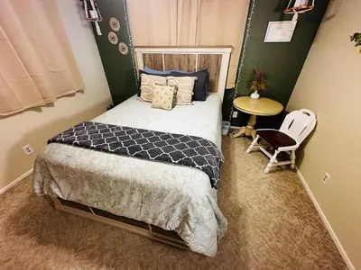 a bedroom with a bed and a table and a chair at Fun for 2-Hot Tub-Dogs Ok-Near Bass Lake in Oakhurst