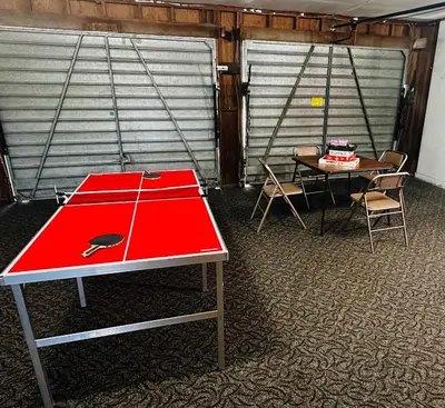 a ping pong table in a room with a table and chairs at Fun for 2-Hot Tub-Dogs Ok-Near Bass Lake in Oakhurst