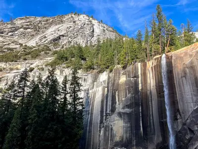 a waterfall on the side of a mountain at Enchanting Creekside Cabin Retreat near Yosemite National Park in California in Oakhurst