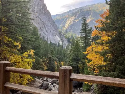 a wooden fence with a view of a mountain at Enchanting Creekside Cabin Retreat near Yosemite National Park in California in Oakhurst