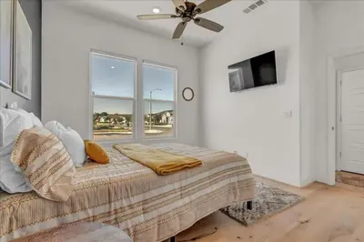 a bedroom with a bed with a ceiling fan and a window at Peaceful Guest Casita with Private Entrance and No Cleaning Fee in Hanford