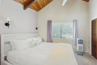 a white bedroom with a bed and a window at Paradise Place in Groveland