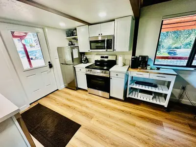 a kitchen with white cabinets and a stove top oven at The Falls-Overlooks a waterfall-BBQ-Sleeps 4 in Oakhurst