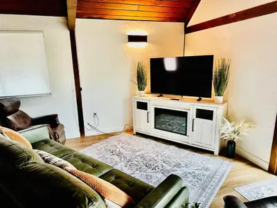 a living room with a couch and a flat screen tv at The Falls-Overlooks a waterfall-BBQ-Sleeps 4 in Oakhurst