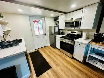 a kitchen with white cabinets and a black stove top oven at The Falls-Overlooks a waterfall-BBQ-Sleeps 4 in Oakhurst
