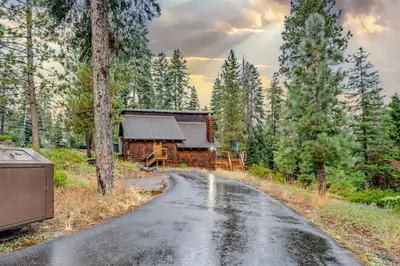 a road leading to a log cabin in the woods at Peaceful Getaway Pet Friendly with Hot Tub and Grill in Tahoe City