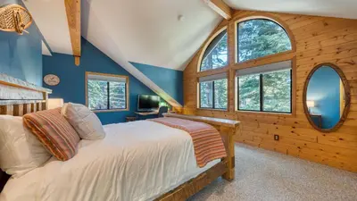 a bedroom with blue walls and windows and a bed at Cozy Escape w Hot Tub Deck Access to Tahoe Donner Skiing Alpenglow Chalet by AvantStay in Truckee