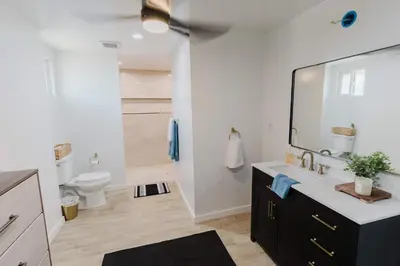 a bathroom with a toilet and a sink with a mirror at Villa Luxury Family Getaway in Patterson