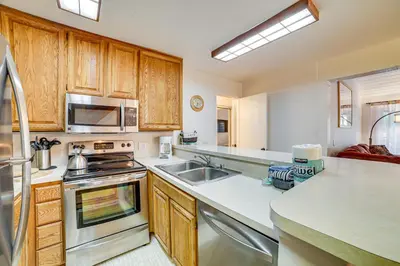 a kitchen with wooden cabinets and a stainless steel appliance at St Anton Condo in Mammoth Lakes! in Mammoth Lakes