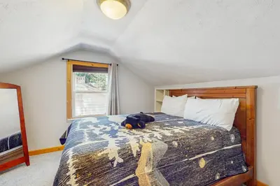 a stuffed animal laying on a bed in a bedroom at Tata Cabin in South Lake Tahoe