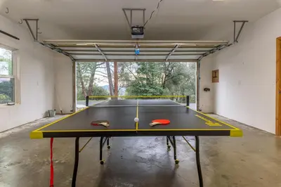 a ping pong table sitting inside of a garage at The Blue Resort of Yosemite - Pool, Spa, Games in Mariposa