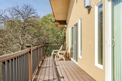 a balcony of a house with a chair on it at Beautiful Lake Views with Hot Tub and Space for Family in Oakhurst