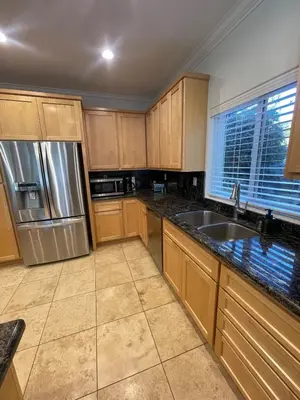 a kitchen with wooden cabinets and a stainless steel refrigerator at Beautiful Lake Views with Hot Tub and Space for Family in Oakhurst