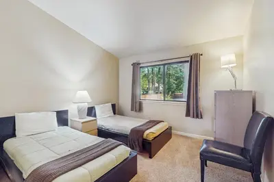 a hotel room with two beds and a chair at My Tahoe Sanctuary in South Lake Tahoe
