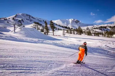 a man is skiing down a snow covered slope at La Vista Blanc 19 in Mammoth Lakes