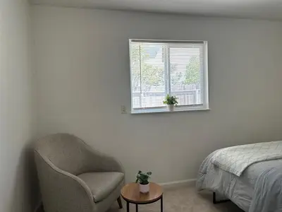 a bedroom with a chair and a window at Suite E with 2-bedroom in Sacramento