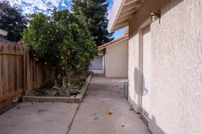 an orange sitting on a sidewalk next to a house at Modern Merced Haven near Merced College and UC Merced in Merced