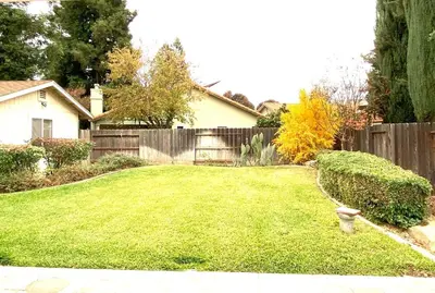 a yard with a fence and a house at Modern Merced Haven near Merced College and UC Merced in Merced