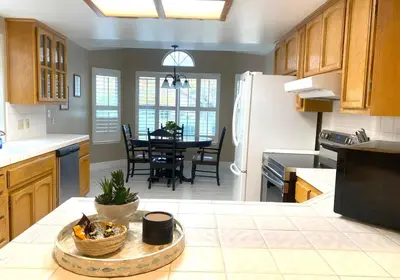 a kitchen with a table and a dining room at Modern Merced Haven near Merced College and UC Merced in Merced