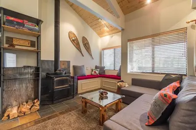 a living room with a couch and a stove at Mammoth Basecamp Condo with Views near Village with AC and Fireplace in Mammoth Lakes