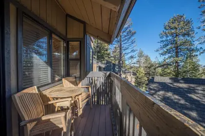 a deck with a table and chairs on a house at Mammoth Basecamp Condo with Views near Village with AC and Fireplace in Mammoth Lakes