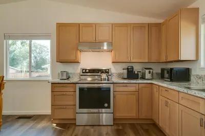 a kitchen with wooden cabinets and a stove top oven at Quiet Home with Yard 2 Mi to Mall and Sparks Marina! in Sparks
