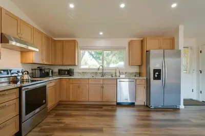 a kitchen with wooden cabinets and a stainless steel refrigerator at Quiet Home with Yard 2 Mi to Mall and Sparks Marina! in Sparks