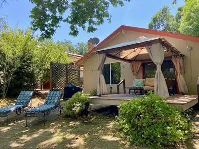 a house with a gazebo and chairs at Riverfront with EV charger - Sequoia River Cottage in Three Rivers