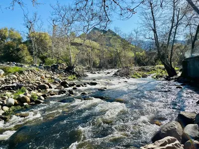 a river with rocks on the side of it at Riverfront with EV charger - Sequoia River Cottage in Three Rivers