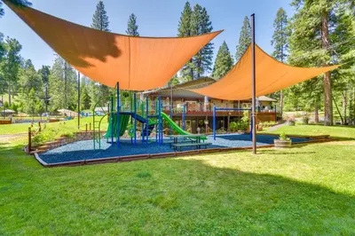 a playground in a park with an orange structure at Sleek Blue Lake Springs Retreat with Deck and Yard! in Arnold
