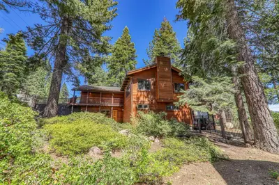 a log home in the woods with trees at Twin Hollow at Dollar Point by Tahoe Getaways - 5BR w Game Room & Hot Tub in Tahoe City