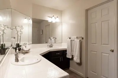 a white bathroom with a sink and a mirror at Yosemite and Bass lake I Hot tub I Game room I Sleeps 13 in Oakhurst