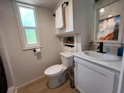 a bathroom with a toilet and a sink and a window at Tiny Blanca at Yosemite Gateway in Groveland