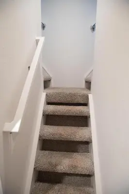 a stairway leading up to a room with white walls at Tiny Blanca at Yosemite Gateway in Groveland