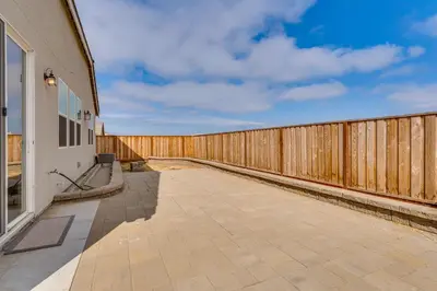 a wooden fence next to a building with a patio at Newly Built Home with Patio 4 Mi to Dtwn Hollister in Hollister