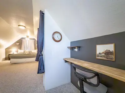 a room with a desk and a clock on a wall at Studio Loft Near Yosemite with Kitchenette in Oakhurst
