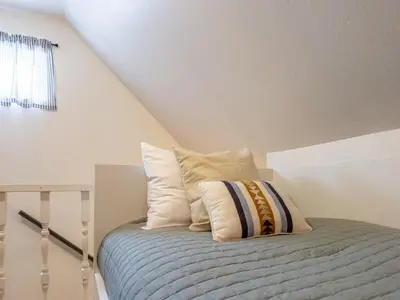 a bed with pillows on it in a attic at Studio Loft Near Yosemite with Kitchenette in Oakhurst