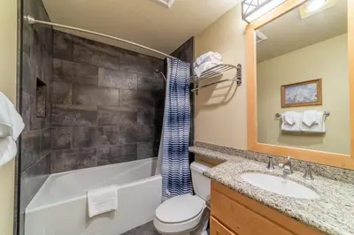 a bathroom with a tub and a toilet and a sink at Ski in/Out 1B/1BA w/ View - Pool, Jacuzzi, Parking in Mammoth Lakes