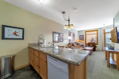 a kitchen with a counter top and a living room at Ski in/Out 1B/1BA w/ View - Pool, Jacuzzi, Parking in Mammoth Lakes