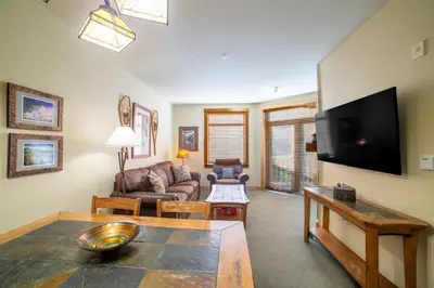 a living room with a couch and a tv at Ski in/Out 1B/1BA w/ View - Pool, Jacuzzi, Parking in Mammoth Lakes