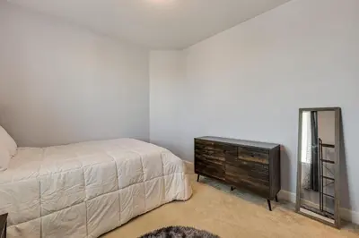 a bedroom with a bed and a dresser and a mirror at 1 Mi to Golf! Spacious and Modern Home in Dinuba in Dinuba